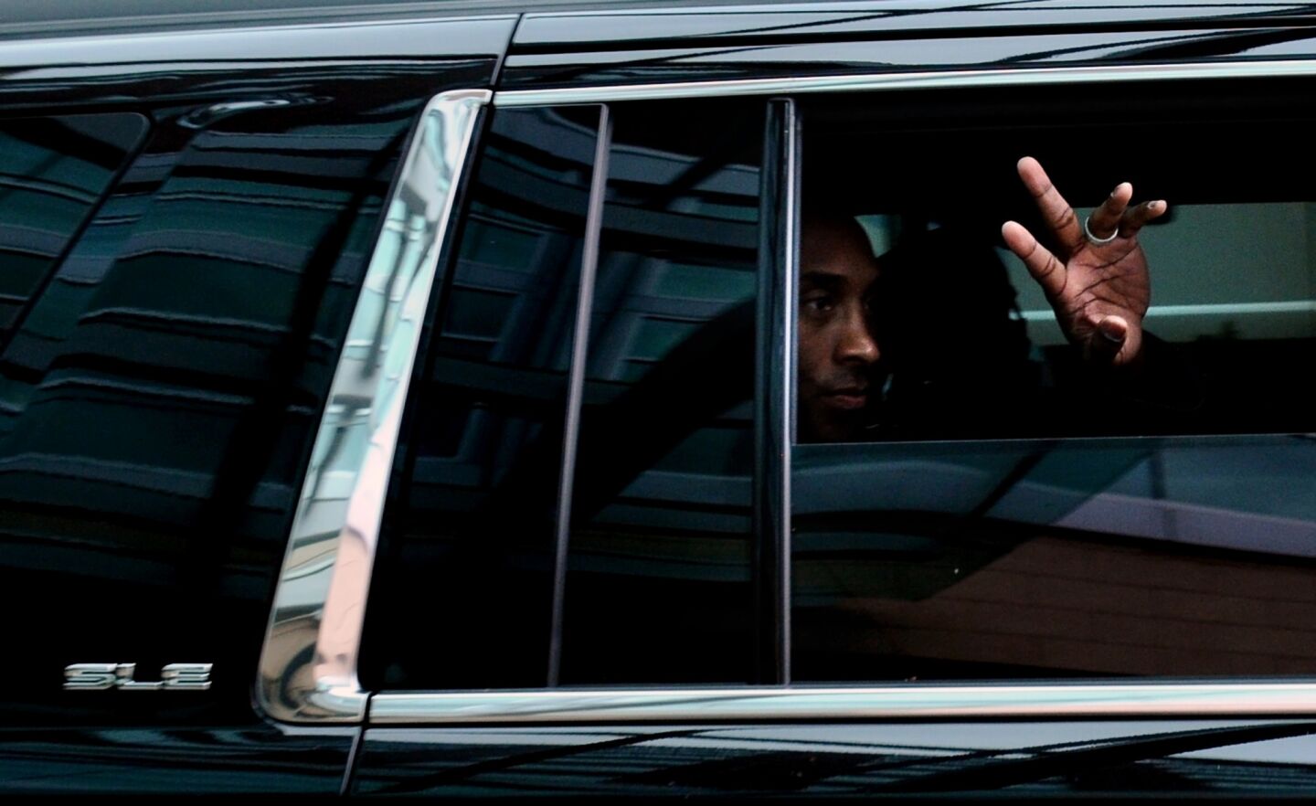 Lakers star Kobe Bryant waves to a cheering crowd from a vehicle outside the Westin Hotel in Memphis, Tenn., beforea game against the Grizzlies on Feb. 24, 2016.
