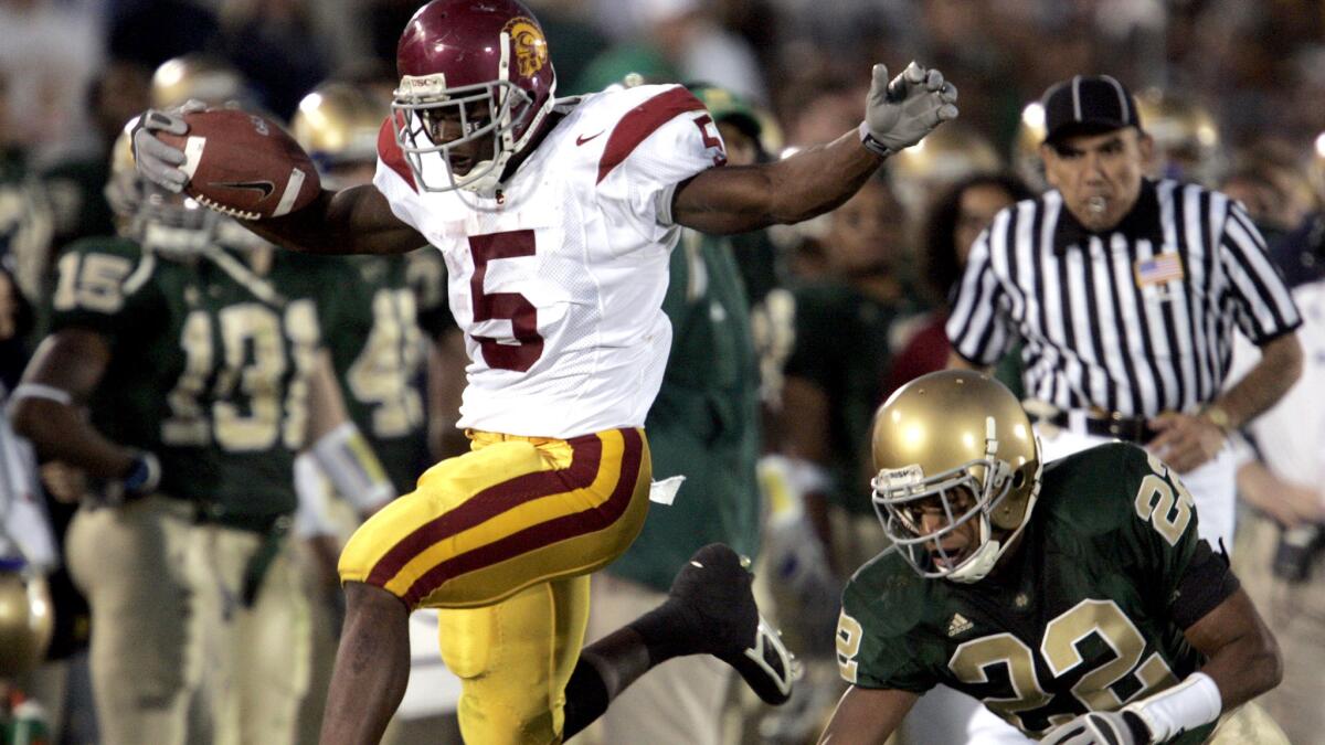 University of Southern California Trojan running back jumps out–of–bounds away from Notre Dame Irish Ambrose Wooden in the fouirth quarter Saturday Oct. 15, 2005 at College Stadium in South Bend, Indiana.