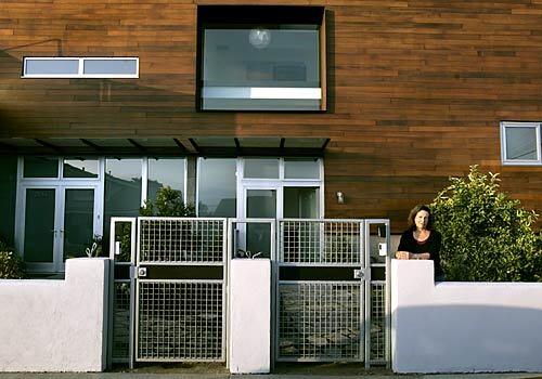Judy Preminger, shown outside the dual units, chose a recycled redwood facade to give the duplex an organic feel. Preminger also had the units under-built at 2,700 square feet to accommodate a garden and included environmentally conscious features. (Christine Cotter./.LAT)