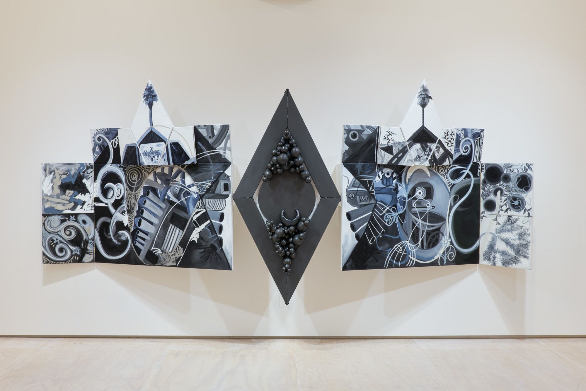 A trio of shaped canvases painted in monochramatic black and white embeds images of L.A. into machine shapes.