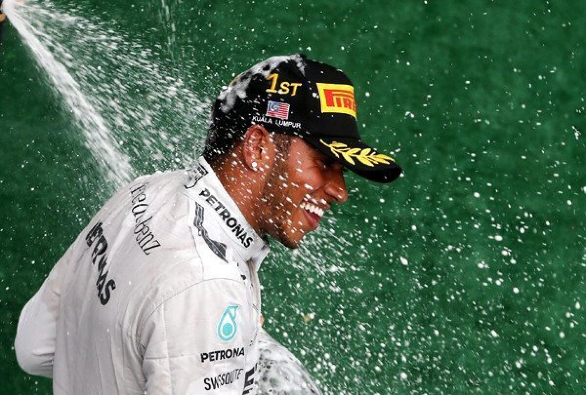 Formula One driver Lewis Hamilton is sprayed with champagne on the podium after he won the Malaysian Grand Prix at the Sepang International Circuit on Sunday.