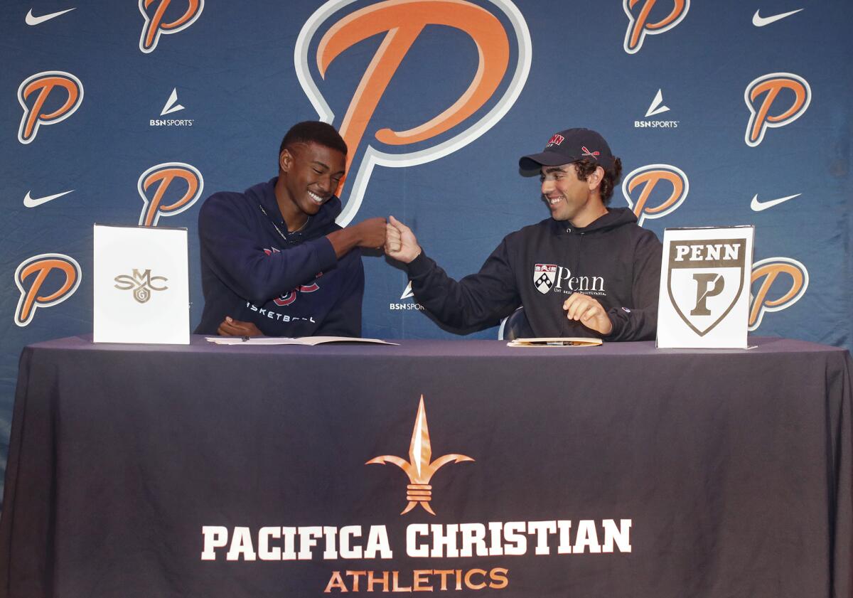 Pacifica Christian Orange County basketball player Judah Brown, left, and rower Dimitri Kallins share a fist bump after committing to colleges on Wednesday. Brown is going to St. Mary's College and Kallins is headed to the University of Pennsylvania.