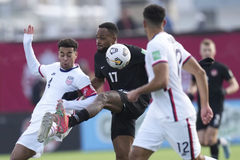 Canada's Cyle Larin (17) battles United States' Tyler Adams (4) for control of the ball during the first half.