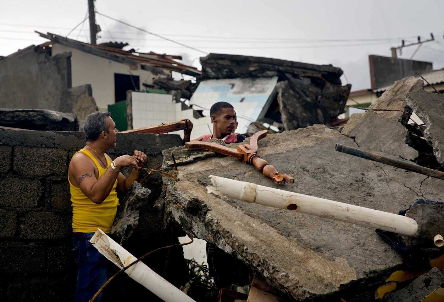 People look to salvage personal belongings from their homes damaged by Hurricane Matthew in Baracoa, Cuba, Wednesday, Oct. 5, 2016.