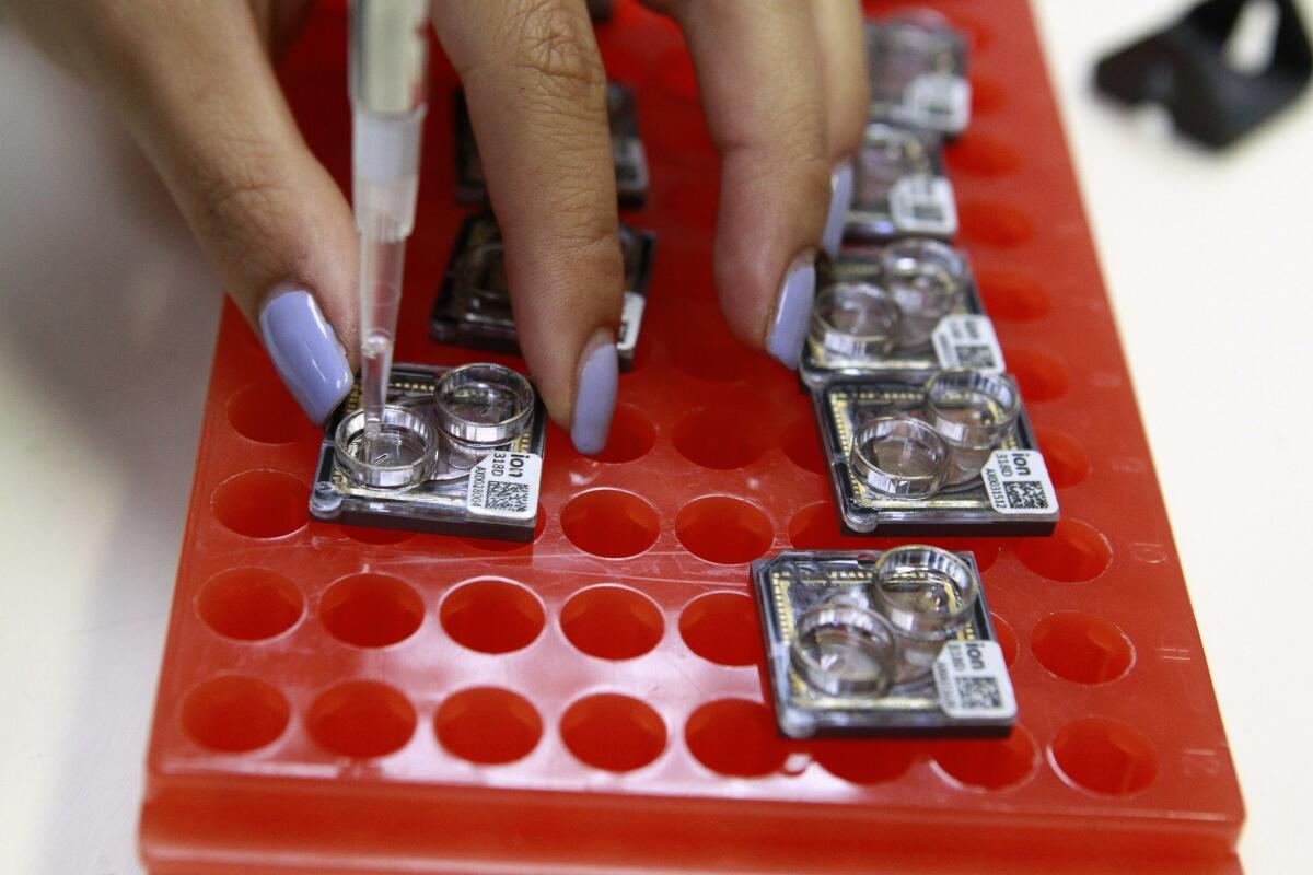 Scientist Kristen Chen places samples onto chips for DNA sequencing on Aug. 12, 2016 at Thermo Fisher in Carlsbad.