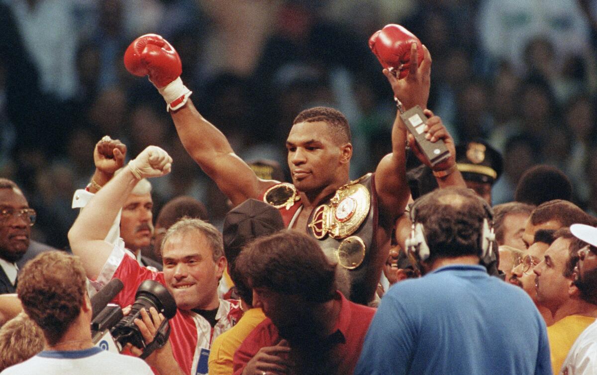 Mike Tyson is lifted by the crowd upon winning his bout with challenger Carl "The Truth" Williams 