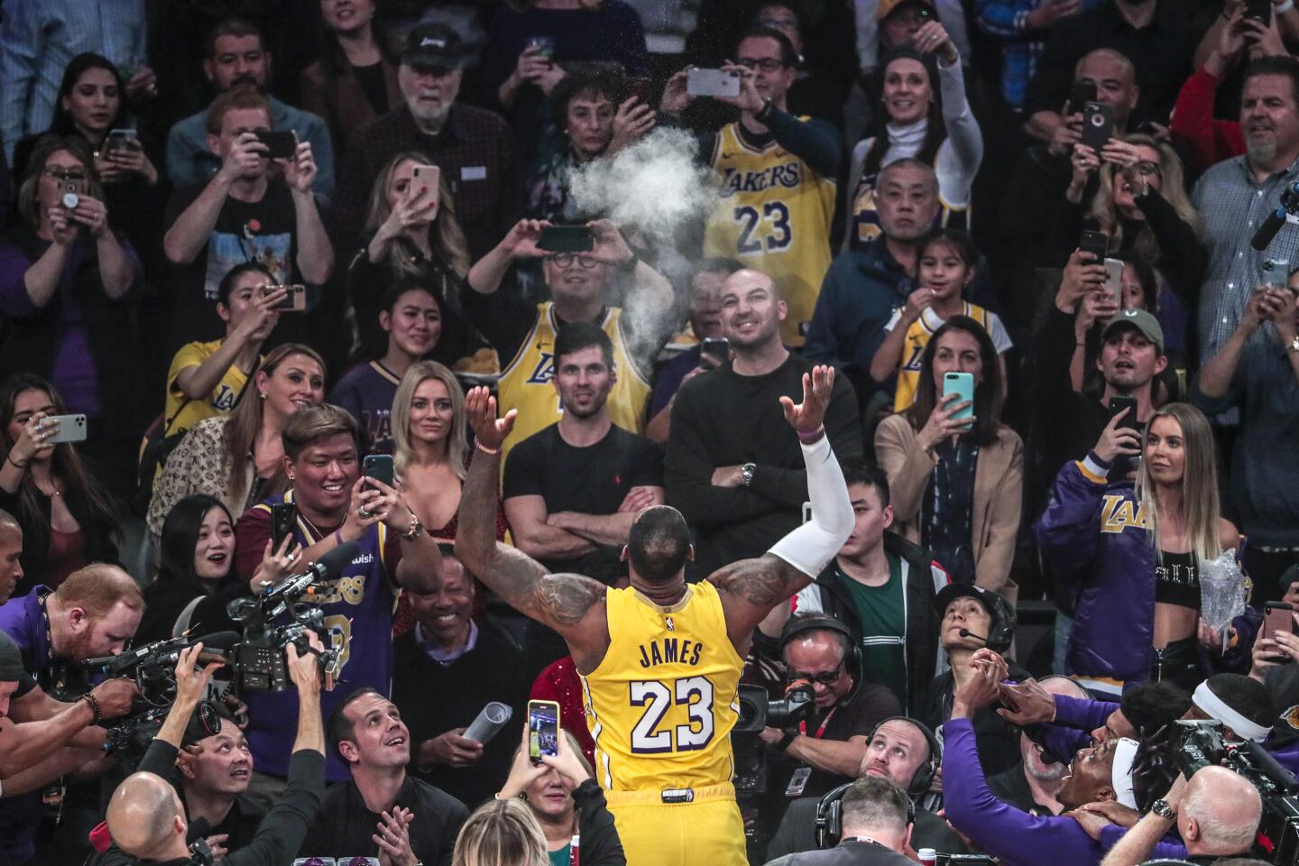 The Lakers' LeBron James tosses powder into the air during his pregame ritual before Friday night's tipoff.
