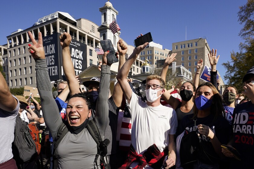 People in Black Lives Matter Plaza react to CNN calling the presidential race in Joe Biden's favor Saturday in Washington.