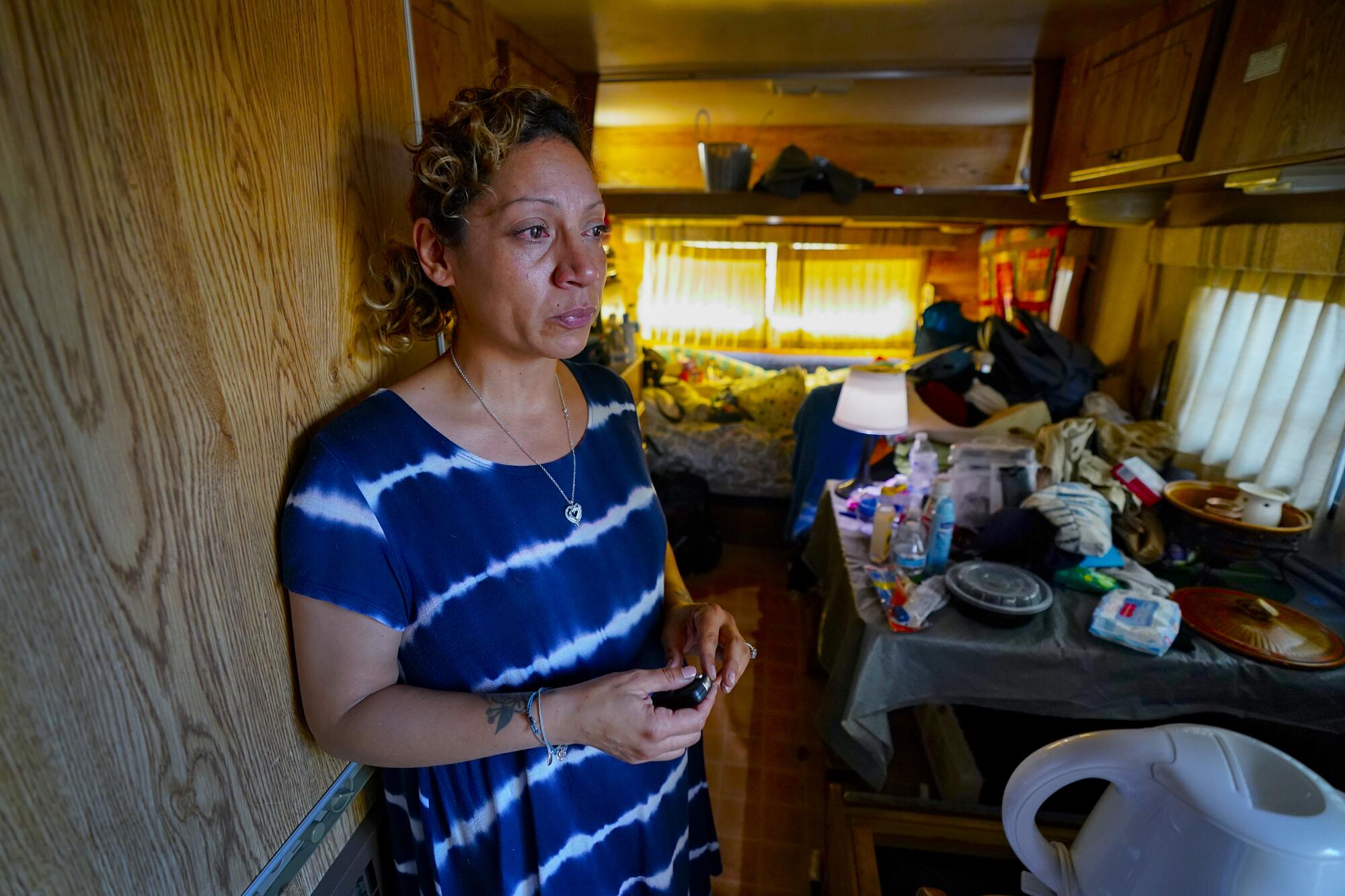 A woman in a cluttered RV trailer