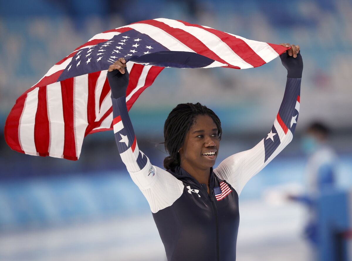 U.S. speedskater Erin Jackson takes a victory lap with an American flag after winning gold.