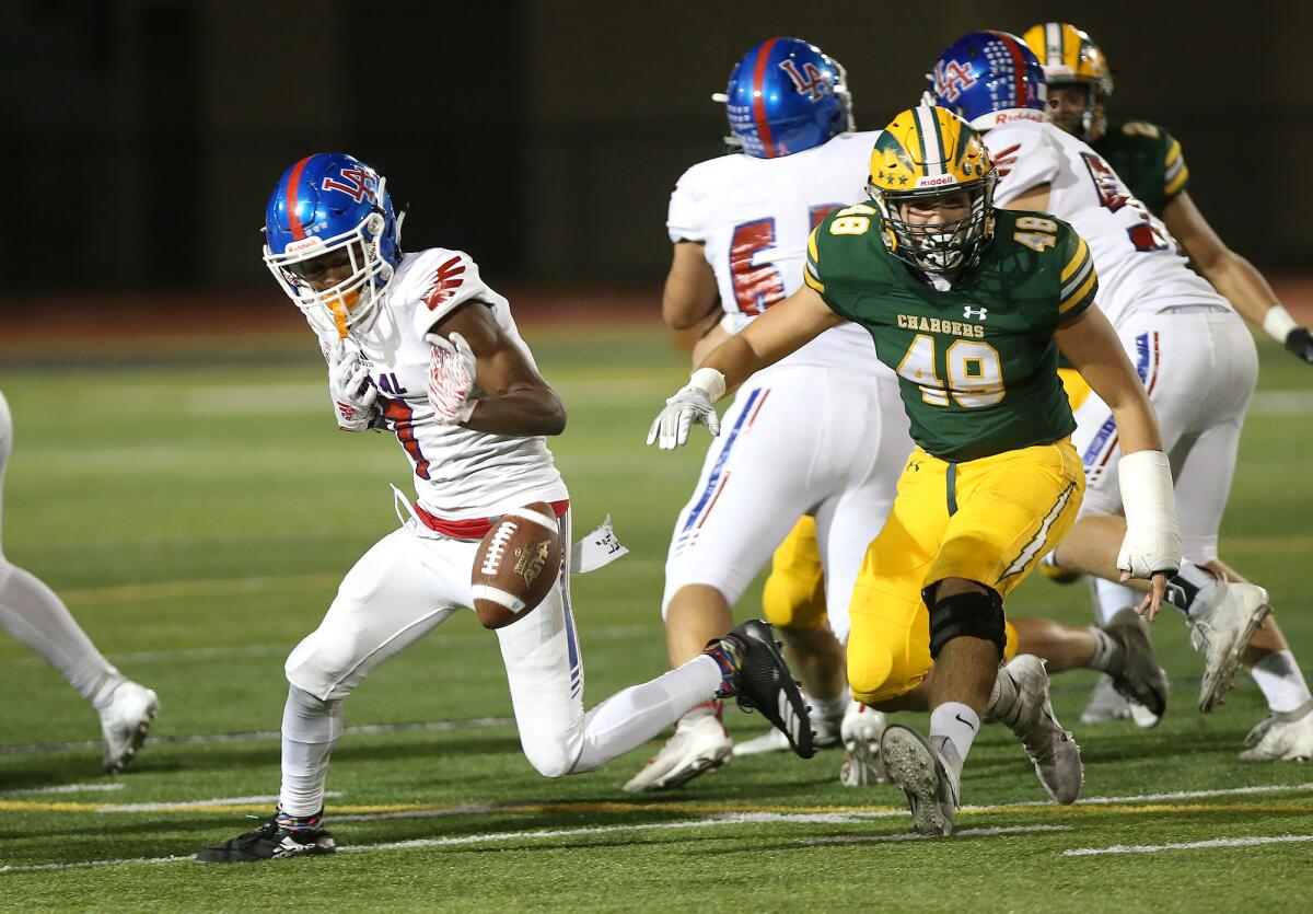 Los Alamitos' Oscar Brown V, left, loses the ball as Edison's Kaleb Joyce (48) gives chase in a Sunset League opener at Huntington Beach High on Friday.