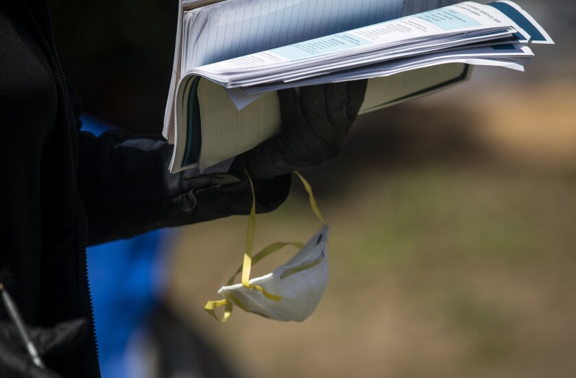 Los Angeles Homeless Services Authority worker with gloves and mask at an encampment