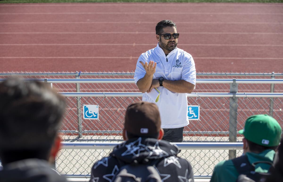 Costa Mesa High's new head football coach Gary Gonzalez speaks with his team on Wednesday.