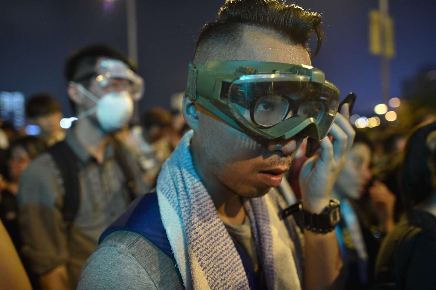 A demonstrator near government headquarters in Hong Kong checks his phone.