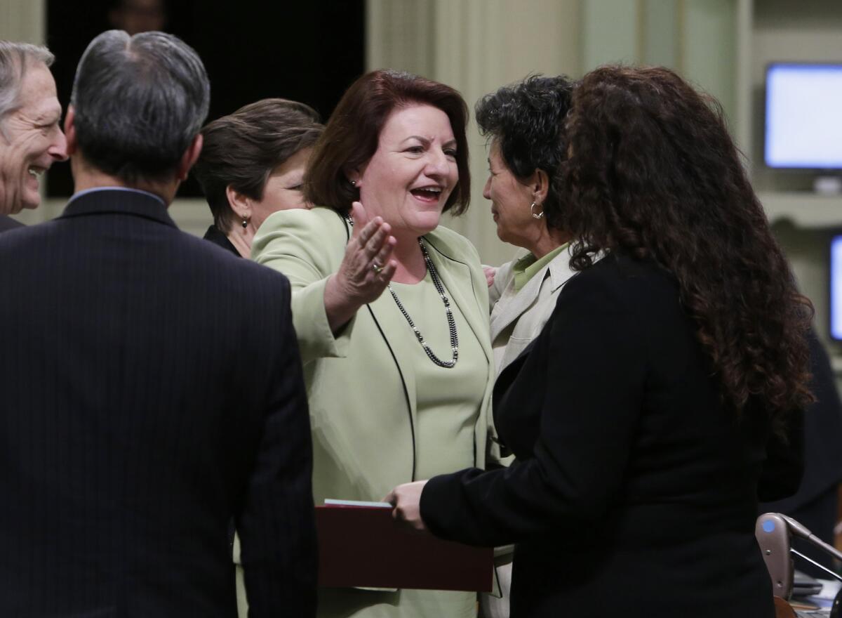 Assemblywoman Toni Atkins (D-San Diego), center, is congratulated by Assemblywoman Lorena Gonzalez (D-San Diego), right, after she was elected Assembly speaker at the Capitol in Sacramento. By a unanimous voice vote, Atkins was elected to replace Speaker John Pérez (D-Los Angeles). Perez says a transition date has not been set but that it will be before summer.