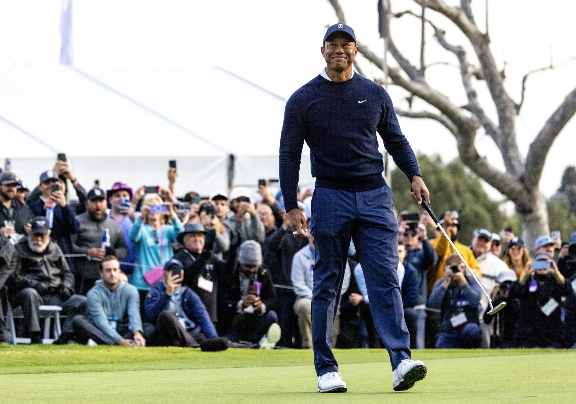Tiger Woods acknowledges the crowd after a birdie on 18 to end his first round.