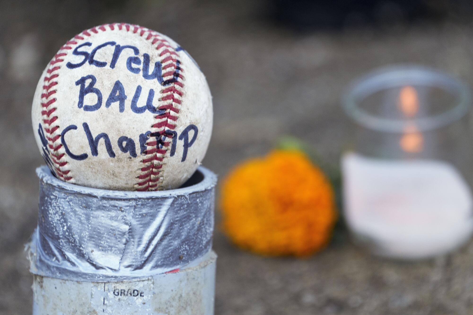 Candles and baseballs are placed outside Dodger St