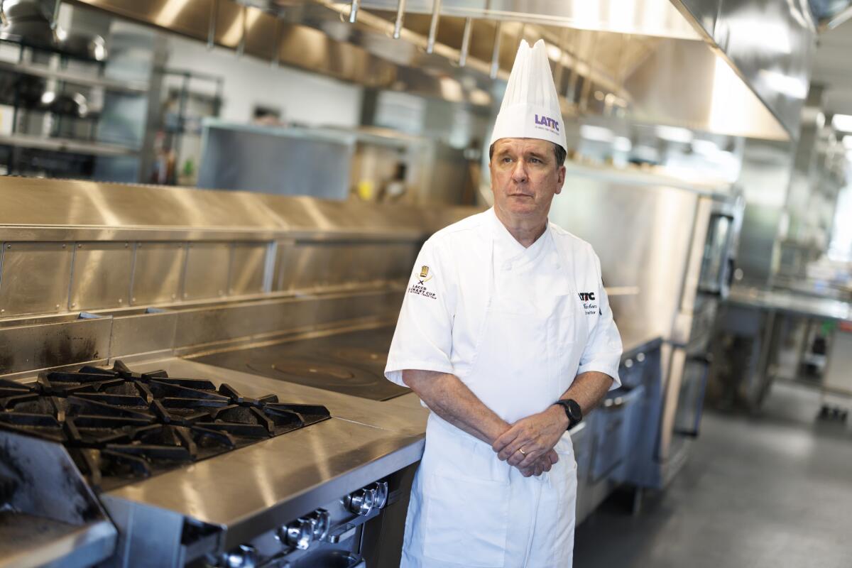 A man with a chef hat stopped near a stove