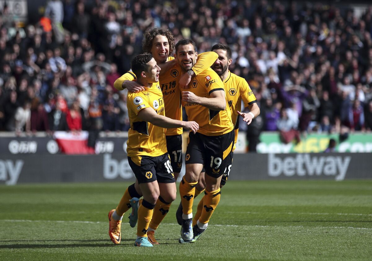 Wolverhampton Wanderers' Jonny, center right, celebrates with teammates after scoring the opening goal during the English Premier League soccer match between Wolverhampton Wanderers and Aston Villa at the Molineux Stadium, Wolverhampton, England, Saturday, April 2, 2022. (Isaac Parkin/PA via AP)
