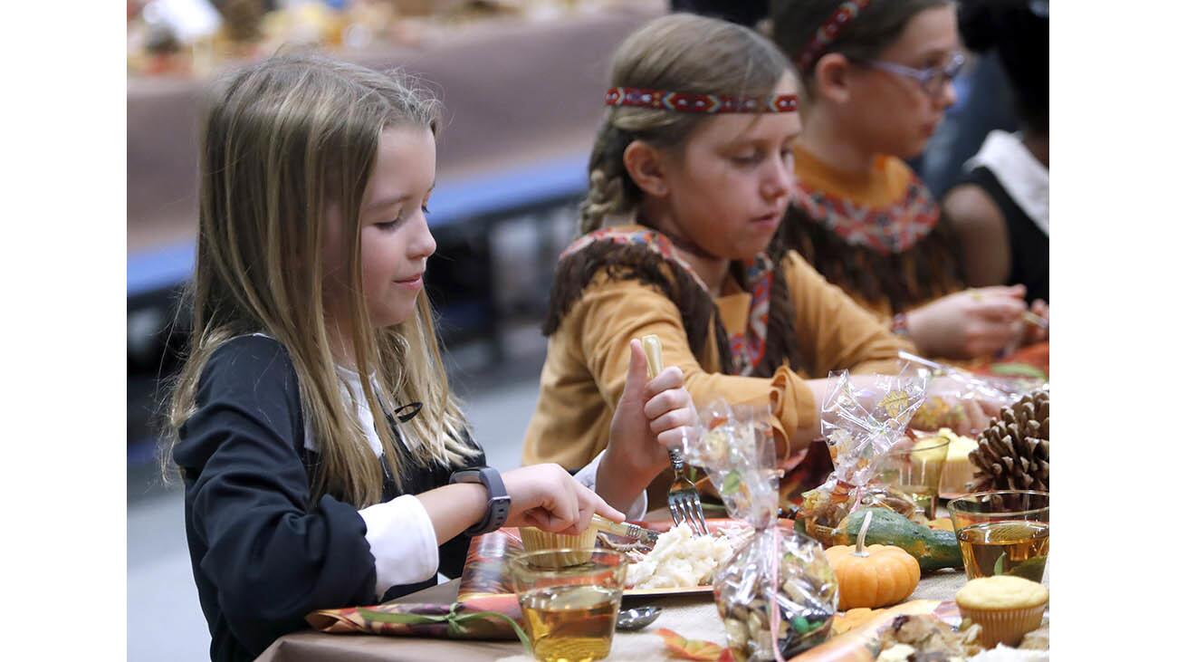 The entire La Cañada Elementary School fifth grade class, including Elina Loos, left, and Mila Wittenberg, enjoyed a Thanksgiving meal at the annual Fifth Grade Feast, dressed as pilgrims and Indians, on the last day of school before the Thanksgiving vacation began at the school in La Cañada Flintridge on Friday, Nov. 17, 2017.