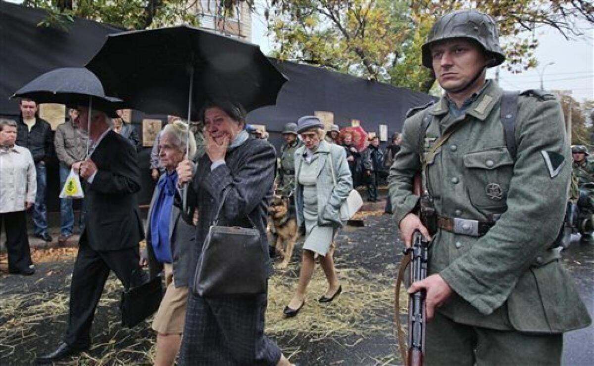 Actors portraying Nazi soldiers reenact the escorting of Jews, portrayed by actors, to the Babi Yar for execution, during a ceremony marking the anniversary of the Babi Yar massacre, in Kiev, Ukraine, Tuesday, Sept. 29, 2009. More than 33,700 Jews were rounded up and shot at Babi Yar over 48 hours beginning on Sept. 29, 1941. In the ensuing months, the ravine was filled with an estimated 100,000 bodies, among them those of non-Jewish Kiev residents and Red Army prisoners of the Nazis. (AP Photo/Efrem Lukatsky)