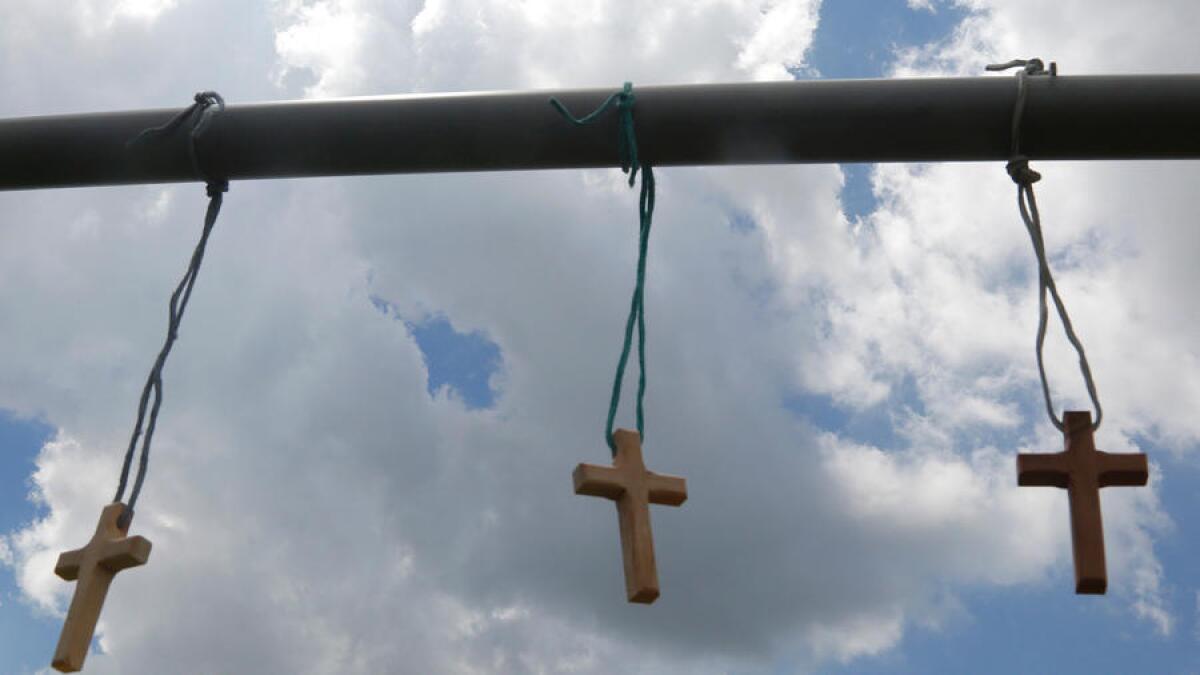 Three wooden crosses are tied to a roadside memorial on Airline Highway, near where the three officers were killed.