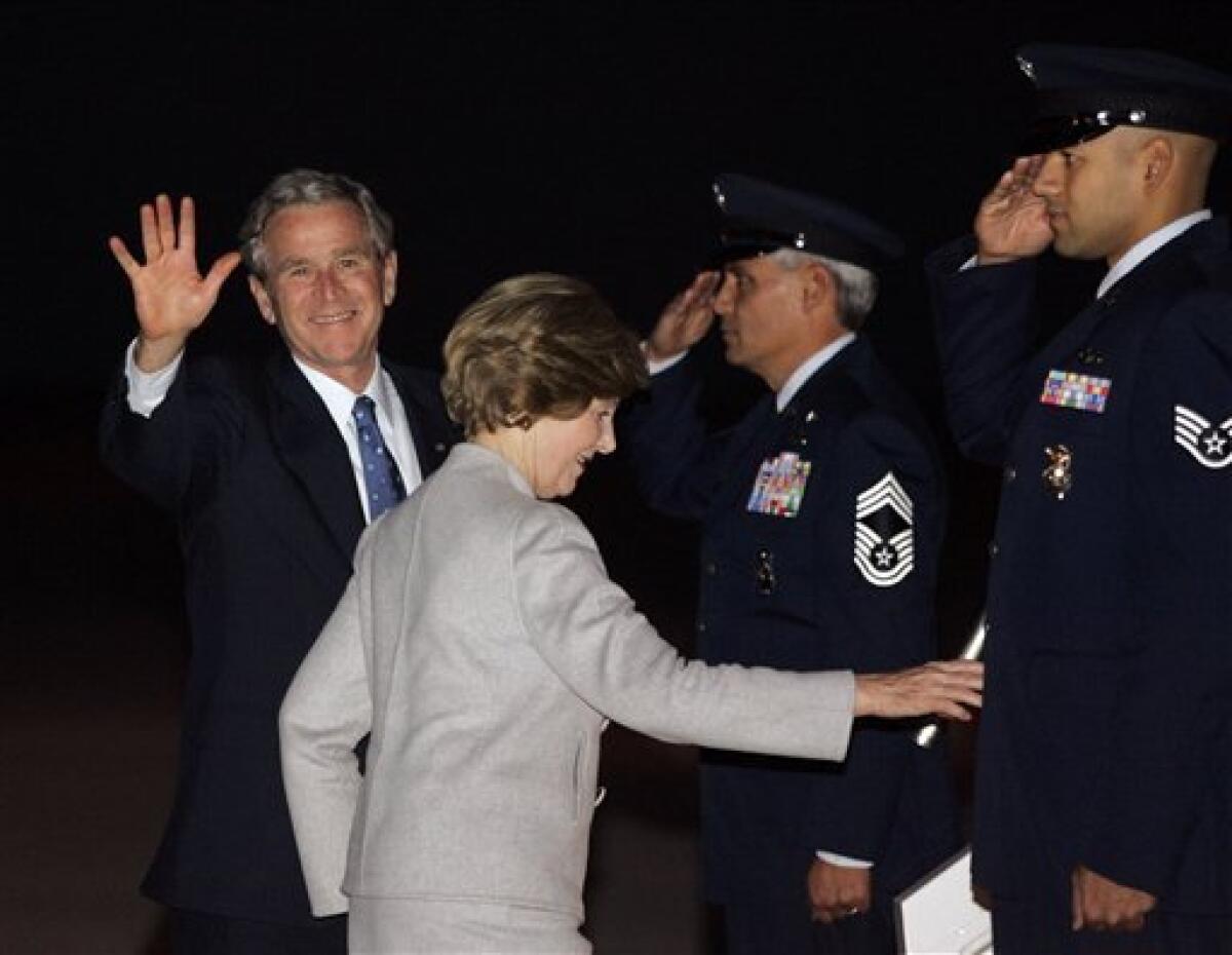 Former President George W. Bush, left, and his wife Laura Bush depart on Special Air Mission 28000 after speaking at a welcome home rally Tuesday, Jan. 20, 2009 in Midland, Texas. (AP Photo/Donna McWilliam)