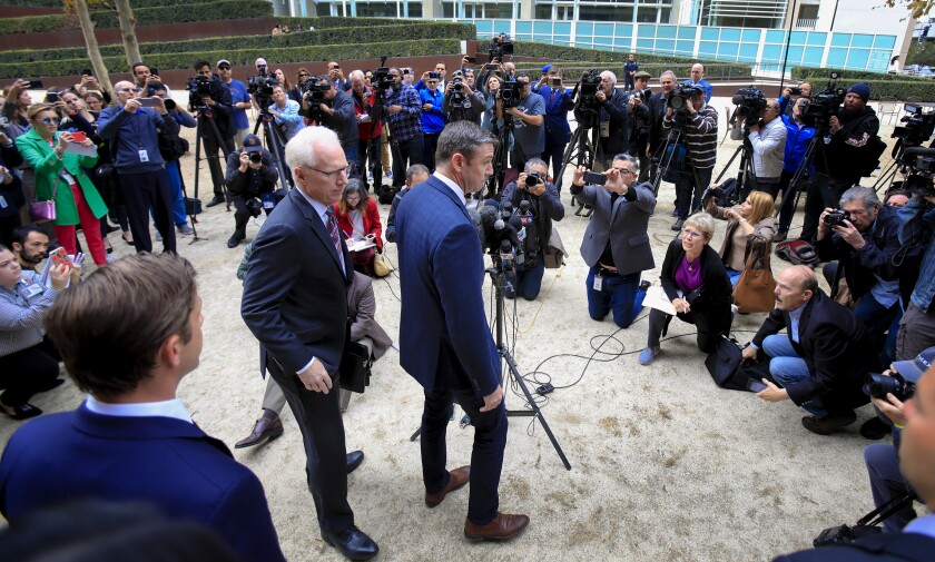 Congressman Duncan Hunter, right, with his attorney, Paul Pfingst, spoke with news reporters outside federal court in San Diego after pleading guilty Dec. 3, 2019.