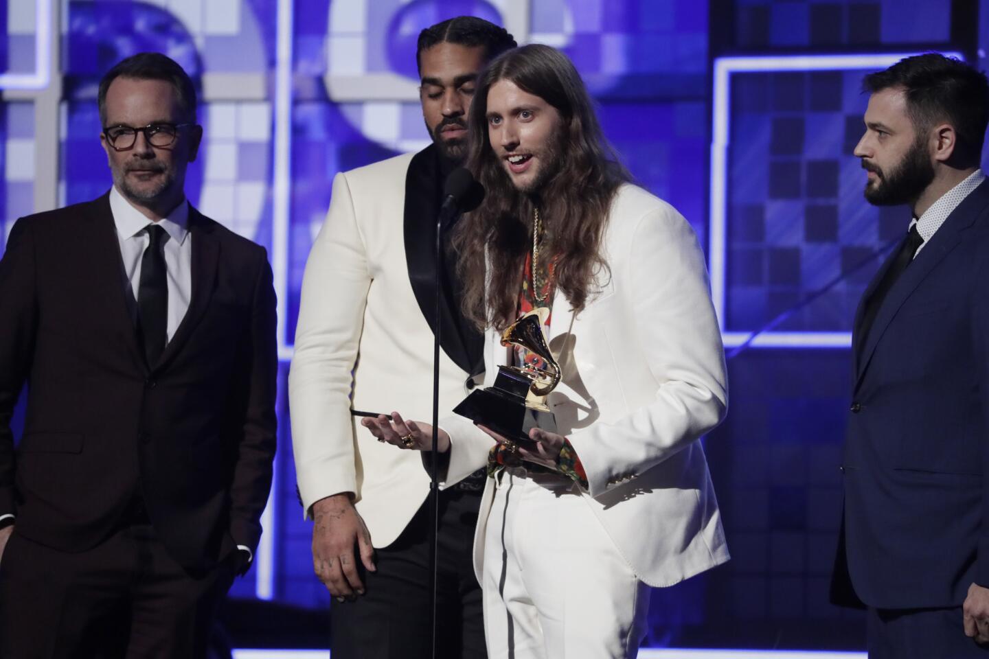 In the middle of the group, Derek Ali, left, and Ludwig Goransson, right, accept the record of the year award for "This Is America" at the 61st Grammy Awards at Staples Center in Los Angeles.