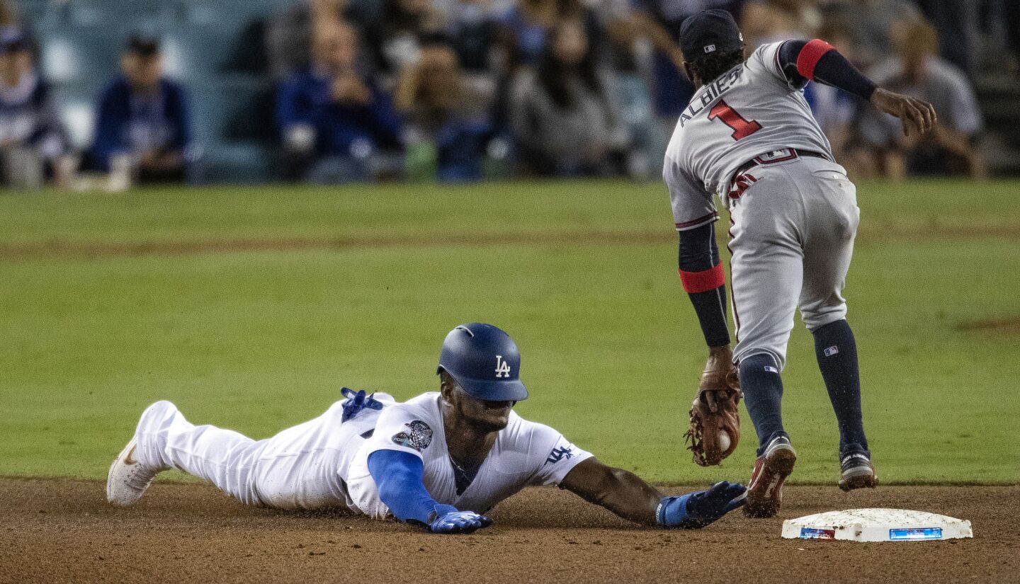 Dodgers right fielder Yasiel Puig steals second base against Atlanta Braves second baseman Ozzie Albies in the fourth inning.