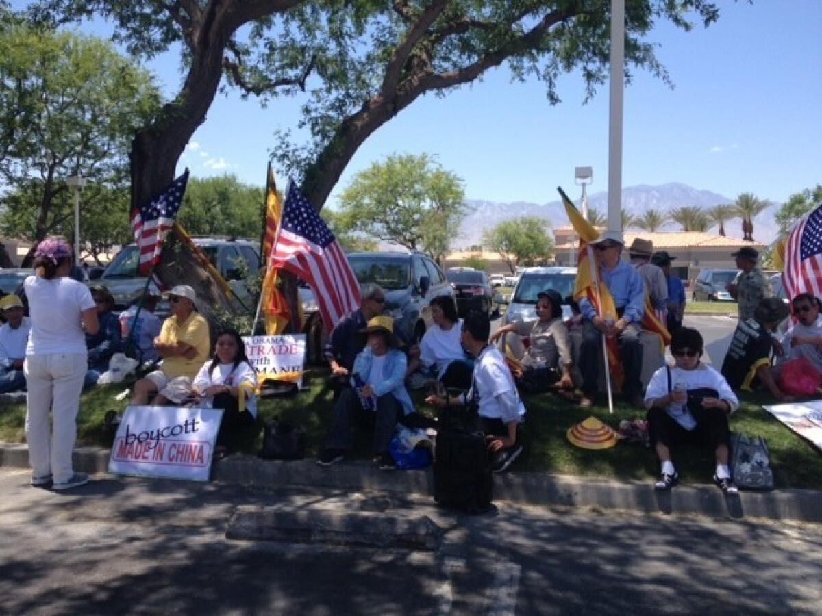 Protesters seek refuge in the shade in Rancho Mirage ahead of a visit by Chinese President Xi Jinping.