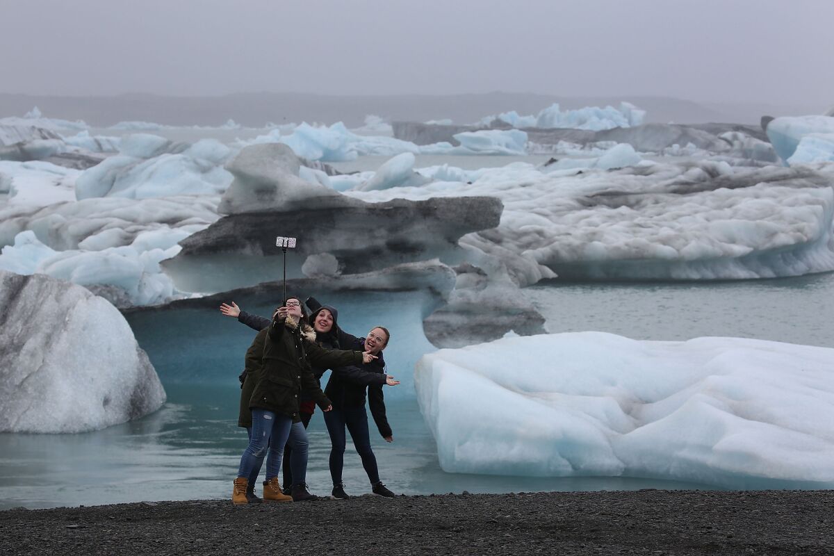 Visitors enjoy the view of icebergs that calved from glaciers in Jokulsarlon, Iceland. Iceland's tourism industry continues to thrive.