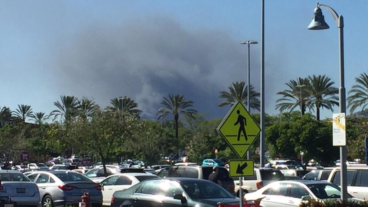 Smoke from a junkyard fire in Sunland is visible from the parking lot of shopping center at Victory Place and Empire Avenue near the 5 Freeway.