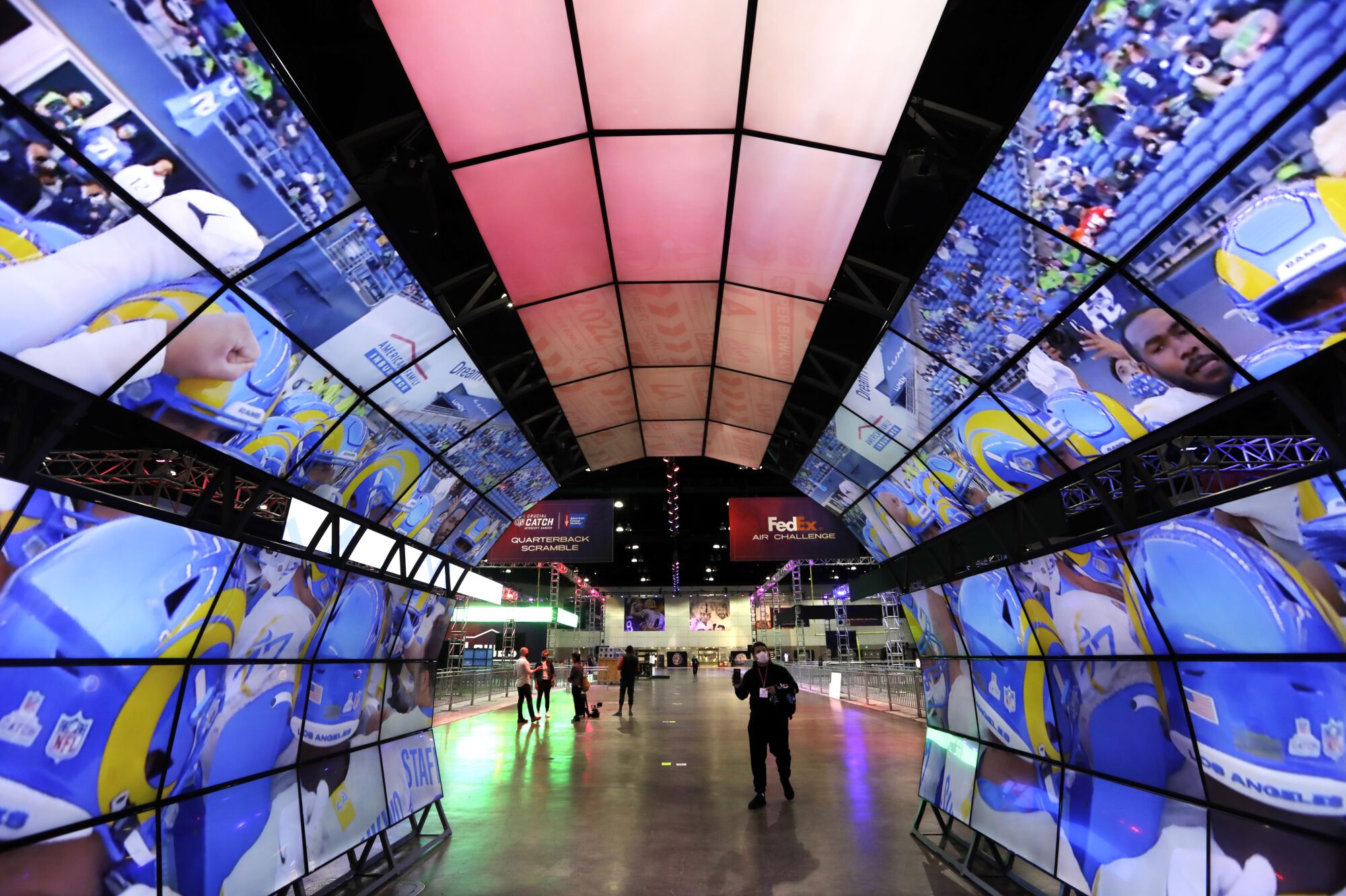 A tunnel covered with video screens that display Rams players in action 