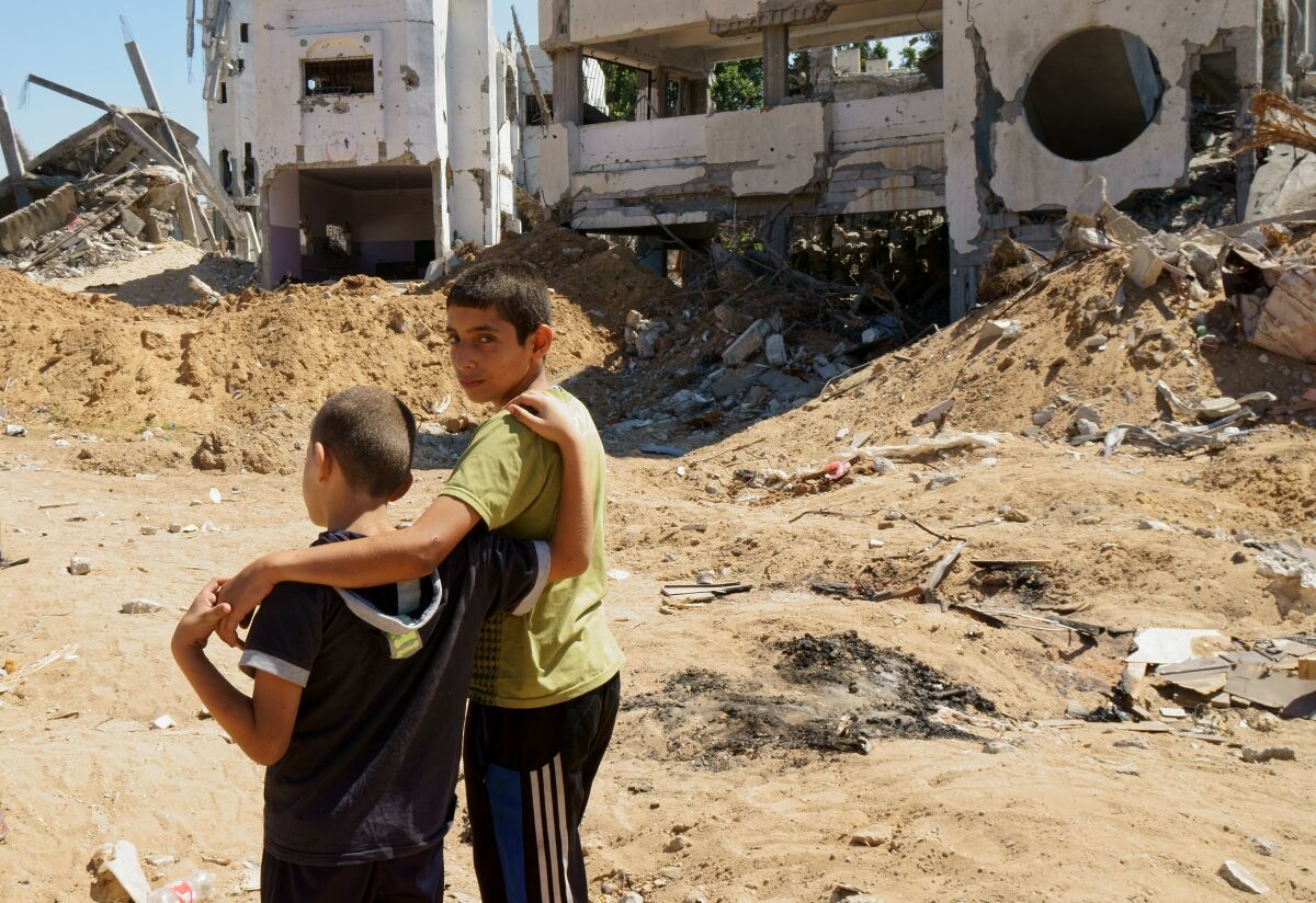 Two brothers from the Gaza City neighborhood of Shuja'iyya stand in front of their house.