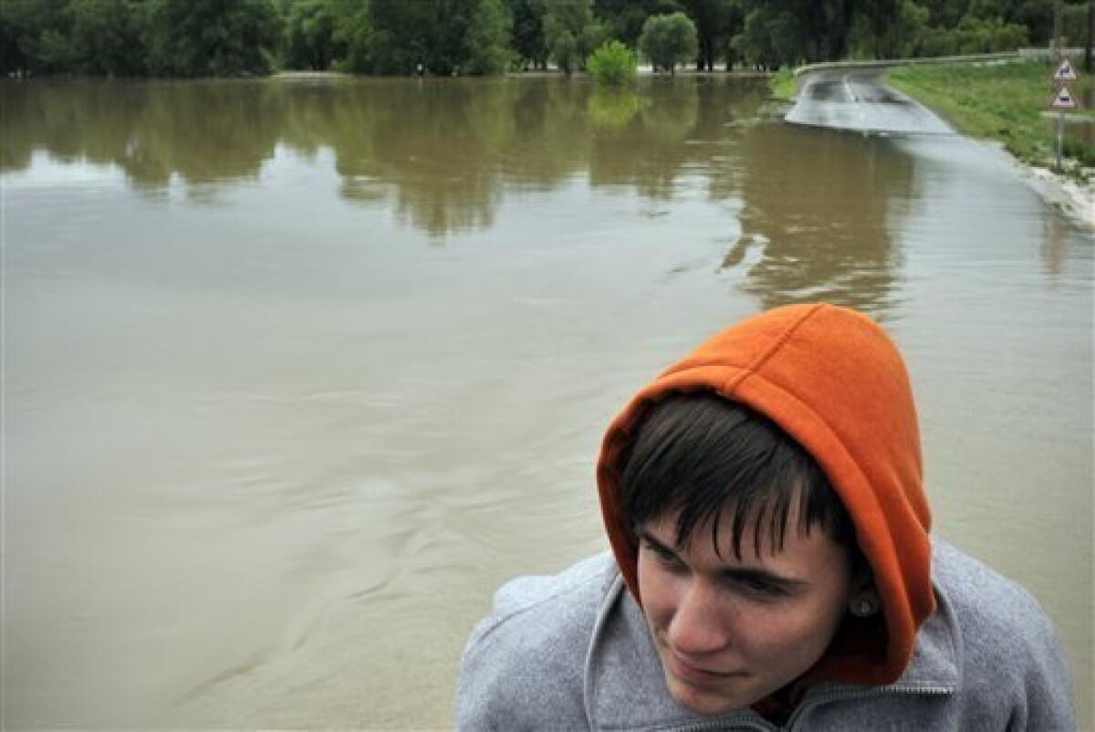 A Hungarian boy looks at the River Hernad while being evacuated through an over-flooded road after the rising water surrounded the village of Kiskinizs, northeastern Hungary, Tuesday, May 18, 2010. Several swollen rivers causing floods throughout Hungary, while roads remain closed due to the unusual wet weather and heavy rains.Heavy rains that began in central Europe last weekend also are causing flooding in areas of Poland , Slovakia and the Czech Republic, with rivers bursting their banks and inundating low-lying homes and roads, and cutting off villages. (AP Photo/Bela Szandelszky)