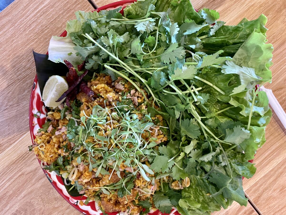 A plate of nem khao and fresh greens