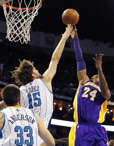 Lakers guard Kobe Bryant scores over Hornets center Robin Lopez to surpass 30,000 points in his career.
