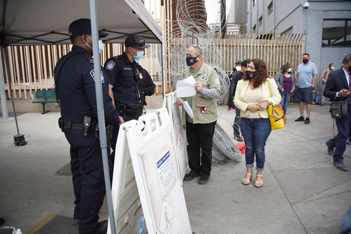 Robert Vivar assists Rocio Rebollar Gomez in talking to CBP officers at San Ysidro 
