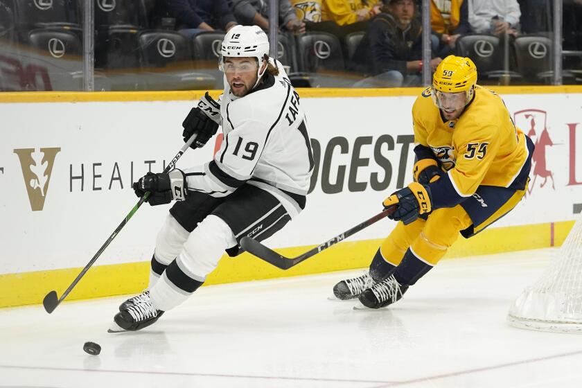 Los Angeles Kings right wing Alex Iafallo (19) moves the puck ahead of Nashville Predators defenseman Roman Josi (59) in the first period of an NHL hockey game Tuesday, Oct. 19, 2021, in Nashville, Tenn. (AP Photo/Mark Humphrey)
