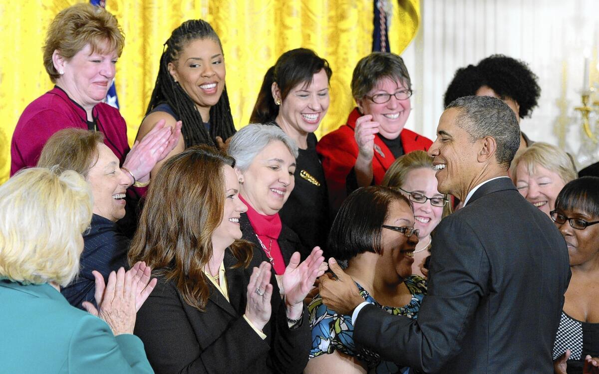 President Obama greets a group of women at the White House to mark his signing of two executive orders designed to bring women's wages more in line with men's.