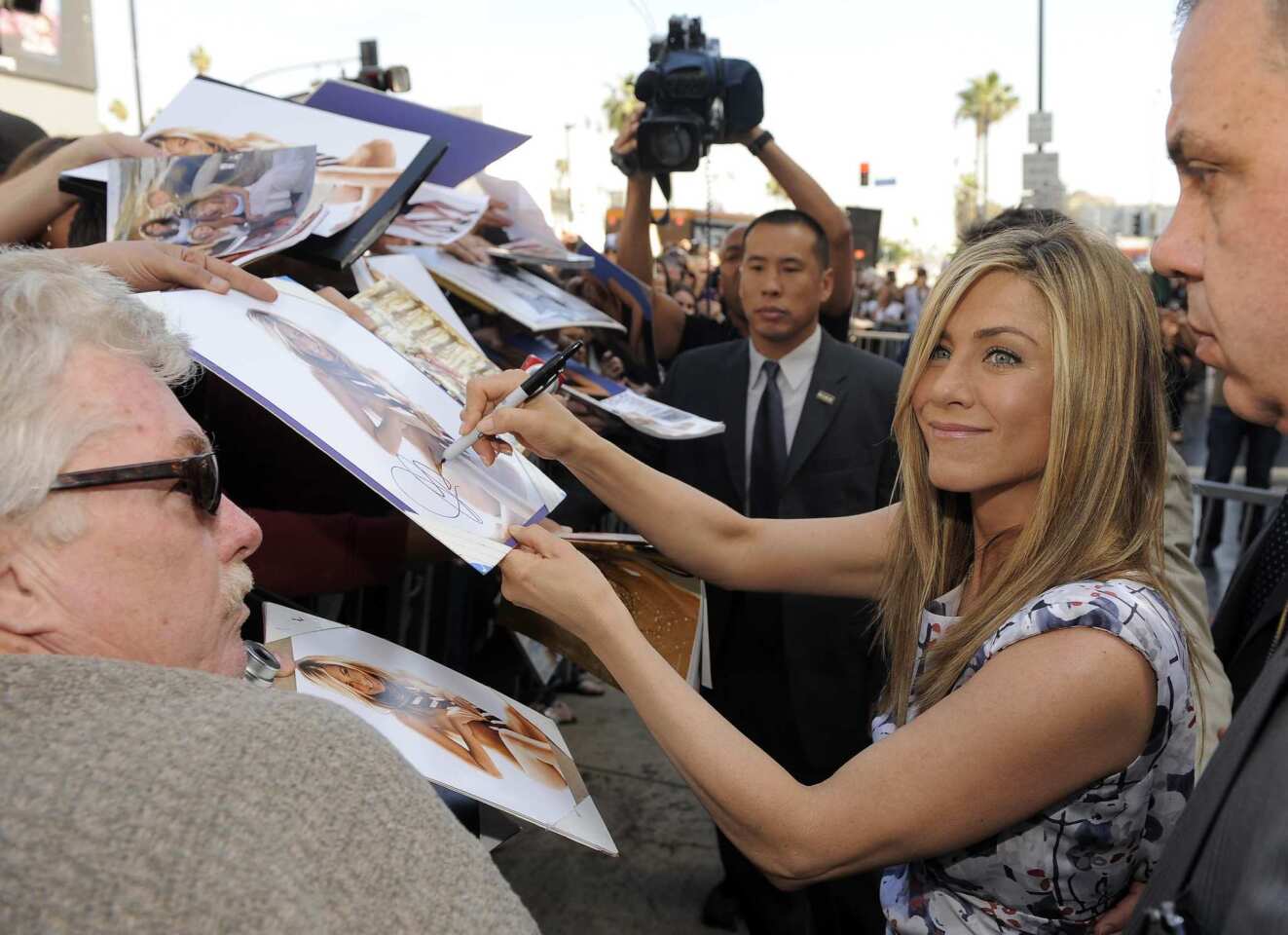 Jennifer Aniston signs autographs for fans in Hollywood.