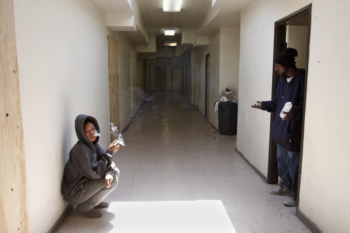 Roxaura Sandoval sits in a hall of a building that houses apartments in what was once office space at 5700 South Hoover St.