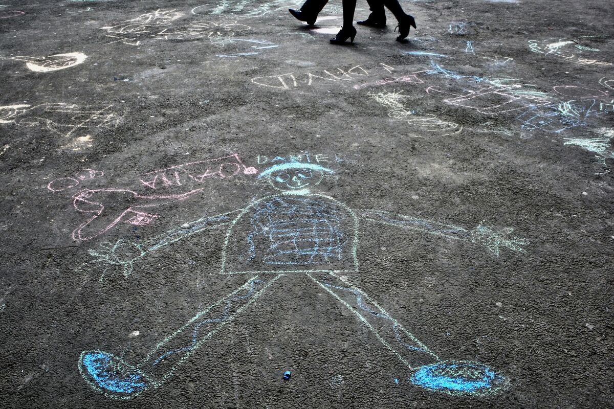 FILE - In this Saturday, April 2, 2011 file photo, pedestrians walk past drawings by autistic children after an event in Bucharest, Romania to mark World Autism Awareness Day. According to a U.S. study published in the New England Journal of Medicine on Wednesday, Oct. 13, 2021, children with autism didn't benefit from an experimental therapy using the hormone oxytocin, thought to promote social bonding. (AP Photo/Vadim Ghirda)