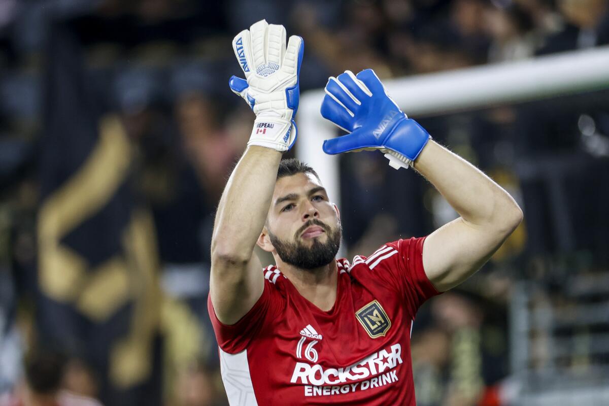 LAFC goalkeeper Maxime Crepeau gestures to fans as he warms up for a match.