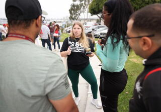 Ariana Assenmacher, center, organizes during a gathering of Republican Party members pressing to vote no on Proposition 50.