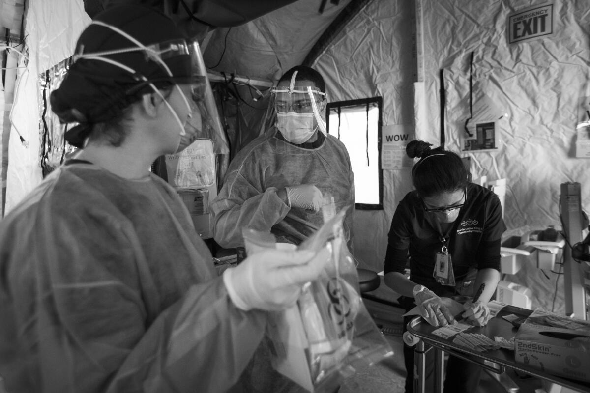 Nurse Sandy Valle, left, EMT Javier Gonzalez and nurse Michelle Kim work in a triage tent at MLK Community Hospital.