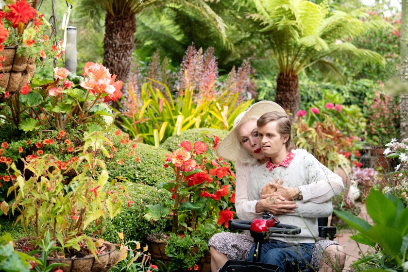 Julie Newmar and her son, John Jewl Smith, 38, use an electric scooter to tour their garden