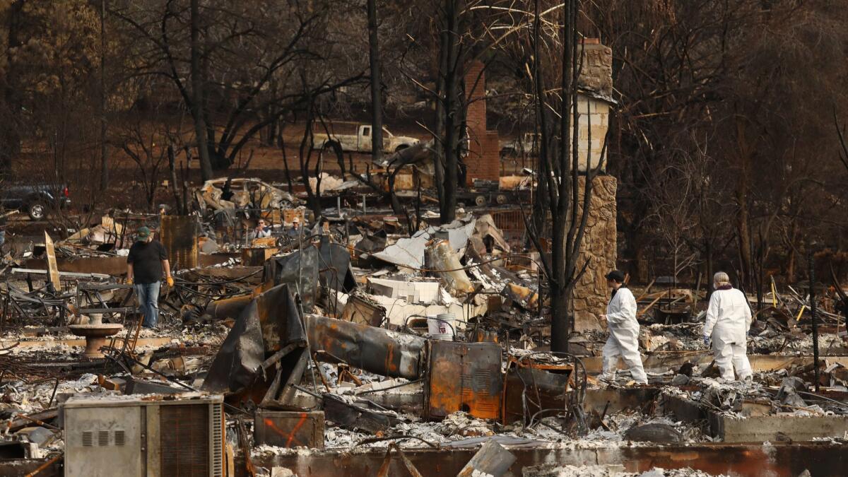 Vicki Taylor, far right, and her family go through their home on Merrill Road in Paradise.