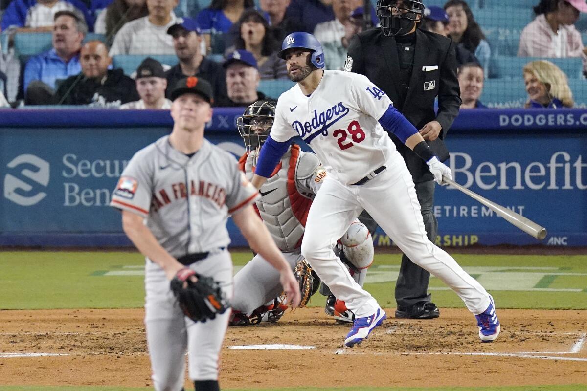 Dodgers' J.D. Martinez heads to first for a solo home run as San Francisco Giants pitcher Kyle Harrison watches.
